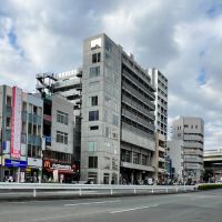 江東区門前仲町の賃貸物件/建物外観。中央の細長いコンクリート打ちっぱなしのビル