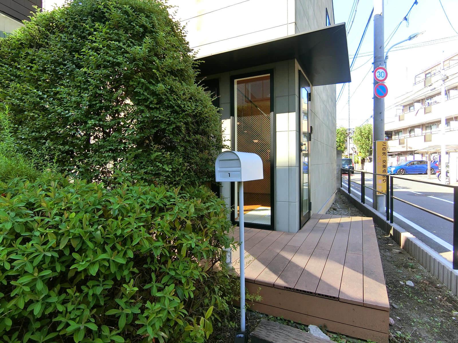 大田区大森中の賃貸物件/ウッドデッキの玄関前、地面から立ち上がる郵便受けがかわいい