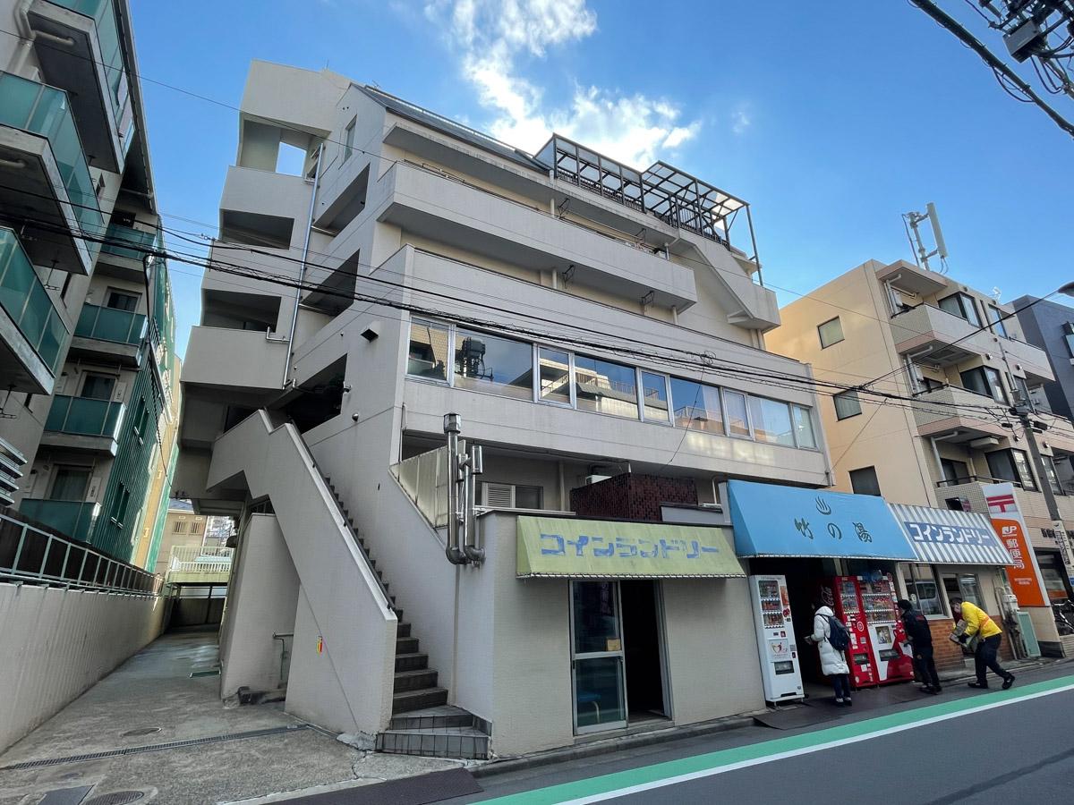 新宿区改代の賃貸物件/外観を南側から。銭湯の入り口とコインランドリーがあります