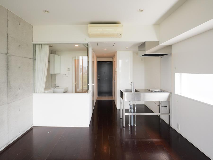 江東区平野の賃貸物件/ベランダ側から室内を見た視点。ガラス張りのトイレとステンレスキッチン、中央奥に見えるのが玄関