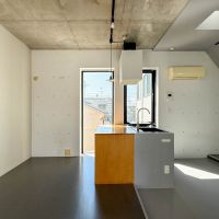 中野区南台の賃貸物件/キッチンに対面するように、木のテーブルが造作されている。西側の隣地は今は開けていますが、これから建物が建ちそう