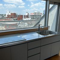 武蔵野市御殿山の賃貸物件/5階：キッチンは3口のIHヒーター。眺望抜けており、窓から見える中央線を目の前にワクワクしながら料理できそう。