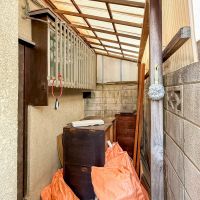 板橋区南町の賃貸物件/勝手口の先には、庇がかかったスペースが。今はリノベーションの資材が置かれていますが、入居後は自転車を置いたりしてもよさそう