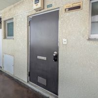 荒川区西日暮里の賃貸物件/玄関ドア（共用廊下から）。築年数を感じる風貌は残っています。