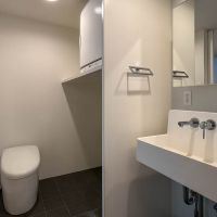 渋谷区代々木の売買物件/洗面、トイレ。トイレの右脇には洗濯機置き場。またその上には洗濯乾燥機がおけるようになっている