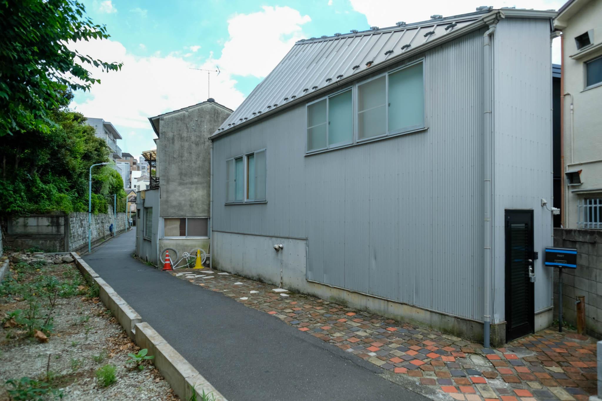 渋谷区広尾の売買物件/変形地に沿って立つガルバリウム鋼板のシルバーの外観。建築家と挑んだ狭小、変形地の空間設計が、複数のメディアでも注目された一軒