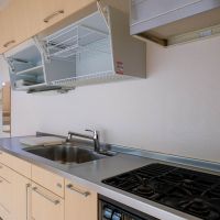 渋谷区広尾の売買物件/プロの料理人だったオーナーがこだわった使いやすさ。収納棚は上に開く仕様。限られた空間を最大限活かす工夫も感じられる