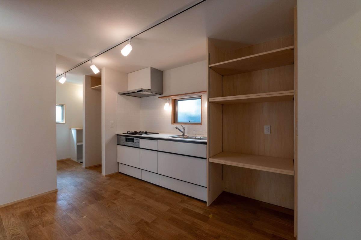練⾺区下⽯神井の賃貸物件/キッチン。右手間には電子レンジや食器が並べられる木製棚。奥に冷蔵庫置き場がつくられています（1階）