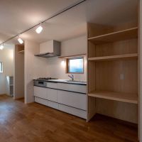 練⾺区下⽯神井の賃貸物件/キッチン。右手間には電子レンジや食器が並べられる木製棚。奥に冷蔵庫置き場がつくられています（1階）