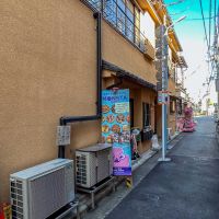 杉並区高円寺北の賃貸物件/建物の出入り口は、商店街から小道に入ったところ。看板が多く、やや雑多な雰囲気