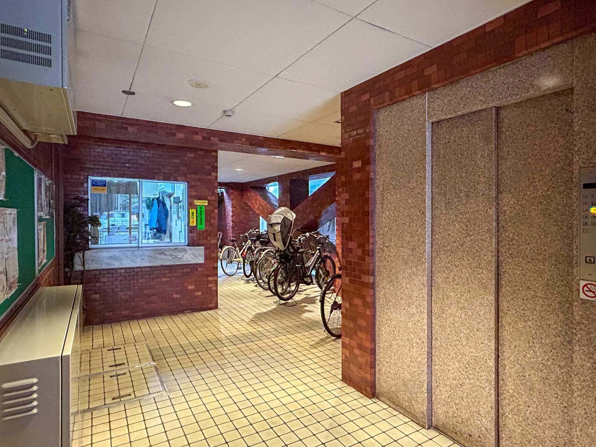 港区三田の賃貸物件/エントランスホール。奥の方に管理室と駐輪場、手前にエレベーター