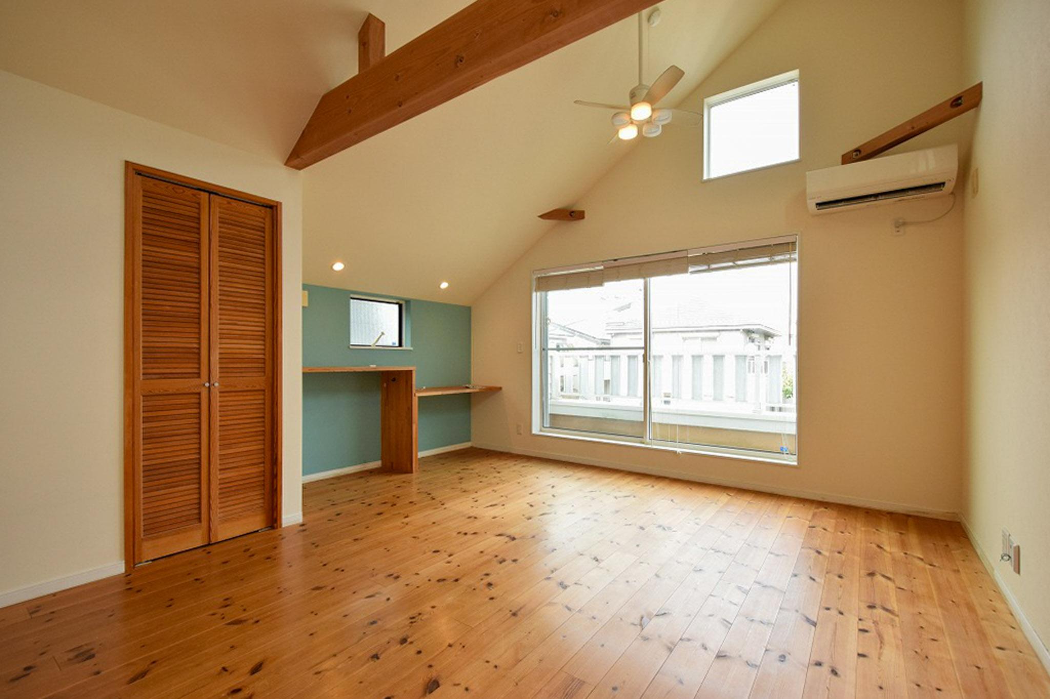 大田区田園調布の賃貸物件/キッチン側から見たLDK。アクセントウォールのターコイズブルーが、木の温もりを引き立てる