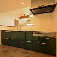 大田区田園調布の賃貸物件/グリーンの収納扉が印象的な対面キッチン。IH3口、食洗機、浄水器完備