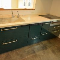 大田区田園調布の賃貸物件/グリーンの収納扉が印象的な対面キッチン。IH3口、食洗機、浄水器完備