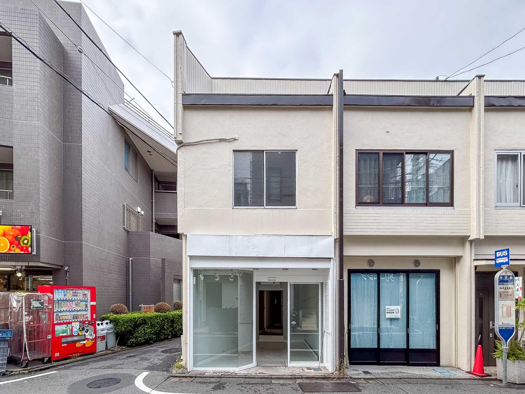 目黒区中央町の賃貸物件/クリーム色に塗装された古い木造長屋。建物の目の前に、渋谷駅まで直通のバス停があります