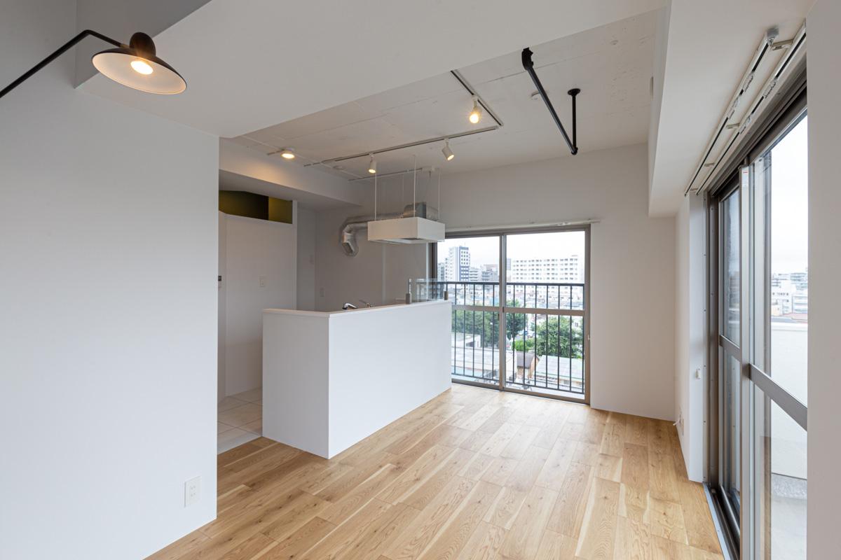練馬区豊玉中の売買物件/床はオークのフローリング、壁は白塗装。ブラックのハンガーパイプやブラケット照明がアクセント