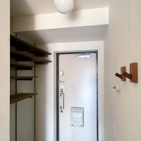 川崎市高津区蟹ケ谷の売買物件/玄関。高さの調整ができるオープンな棚が靴箱に。天井の照明は真鍮とガラスボールの組み合わせがかわいい