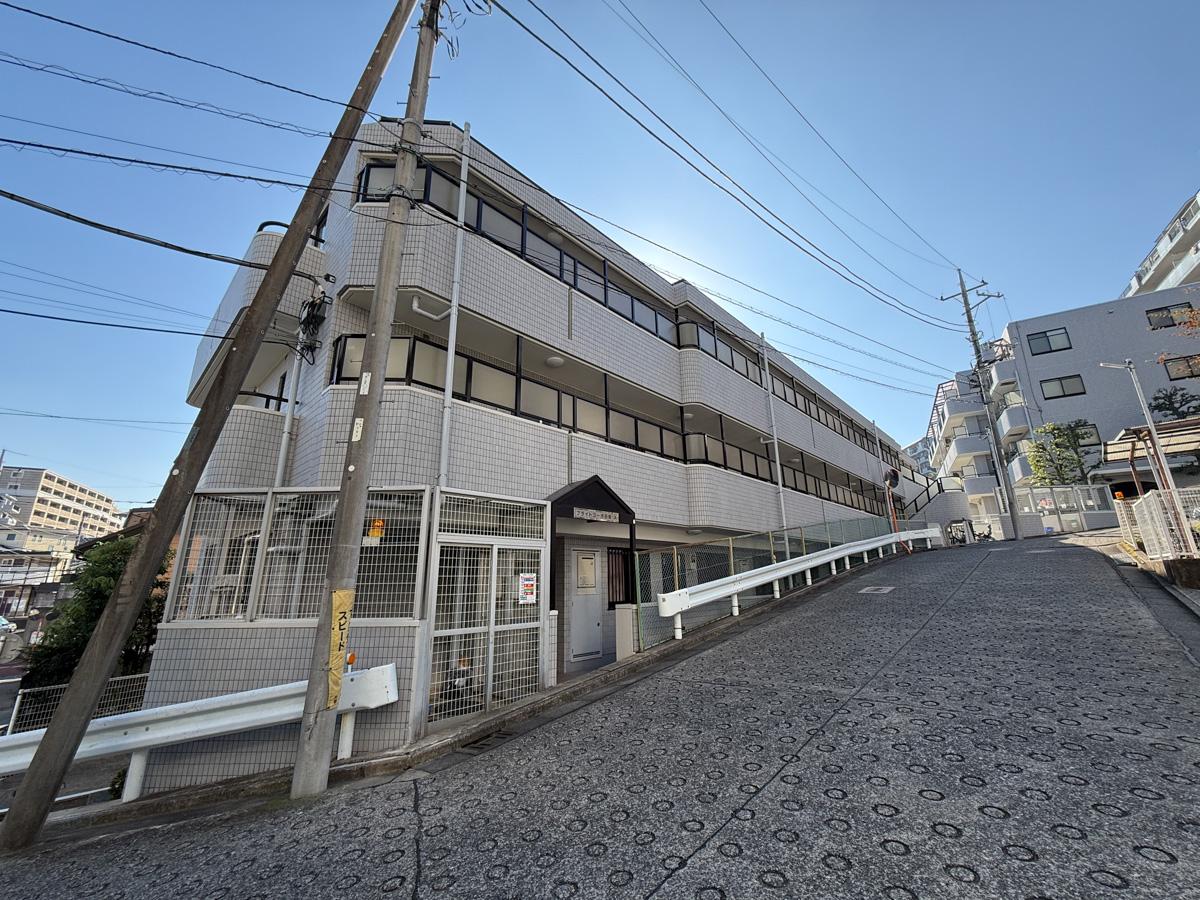 川崎市高津区蟹ケ谷の売買物件/外観。坂道の途中に建つ低層マンション
