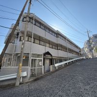 川崎市高津区蟹ケ谷の売買物件/外観。坂道の途中に建つ低層マンション