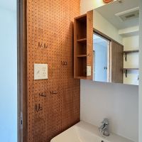 川崎市高津区蟹ケ谷の売買物件/洗面室のデザインもかわいい。ラワンの有孔ボードには、ドライヤーや小物などがかけられるつくりに