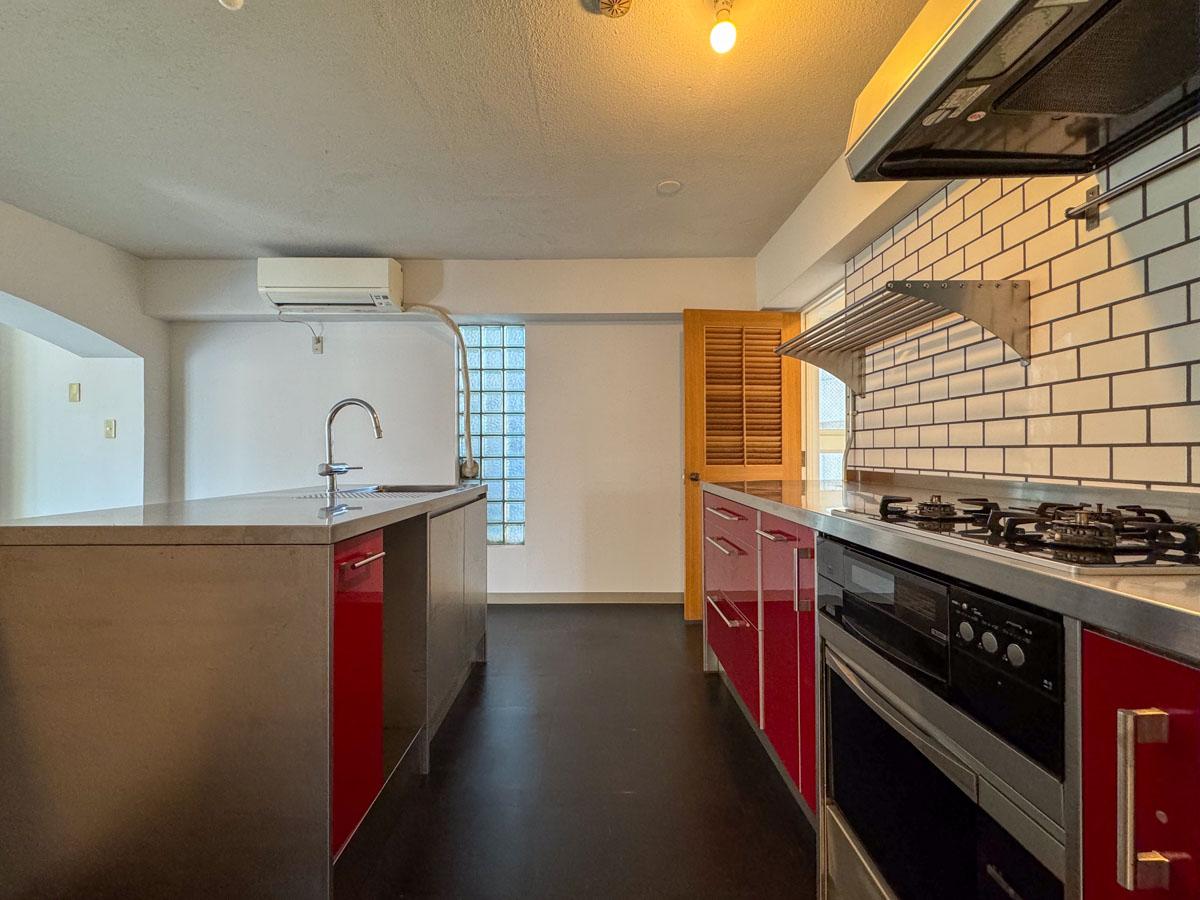 渋谷区神宮前の売買物件/赤いパネルがポップな印象のキッチン