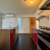 渋谷区神宮前の売買物件/赤いパネルがポップな印象のキッチン