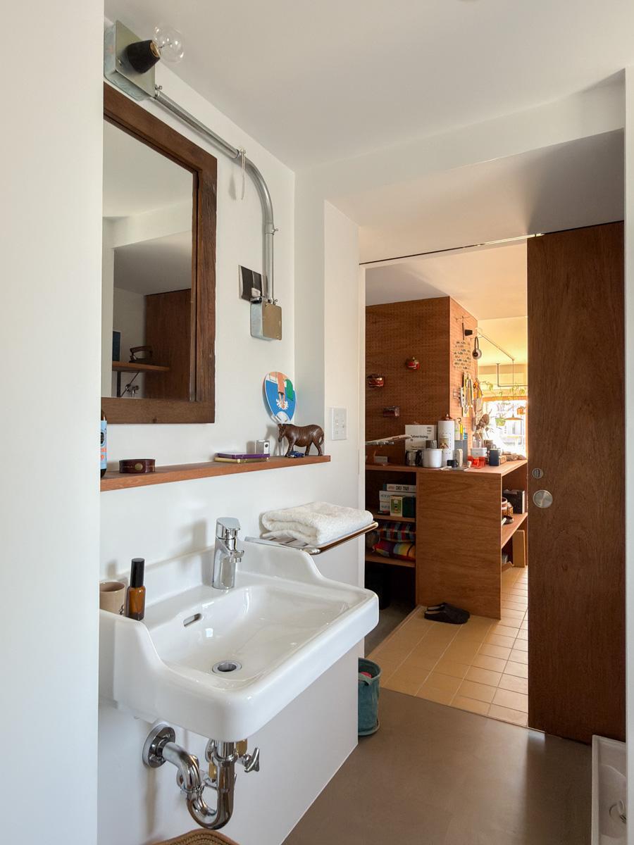 世田谷区池尻の賃貸物件/洗面。鏡の下はニッチのつくりで洗面用品が置ける仕様。また洗面シンクの横にはホテル金物の棚があり、タオルを置いたり、ドライヤーをかけたりできる