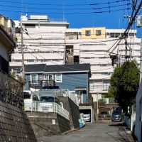 川崎市宮前区神木本町の売買物件/マンションを下から見た写真。傾斜地に階段状に立てられた、そそる姿のマンション