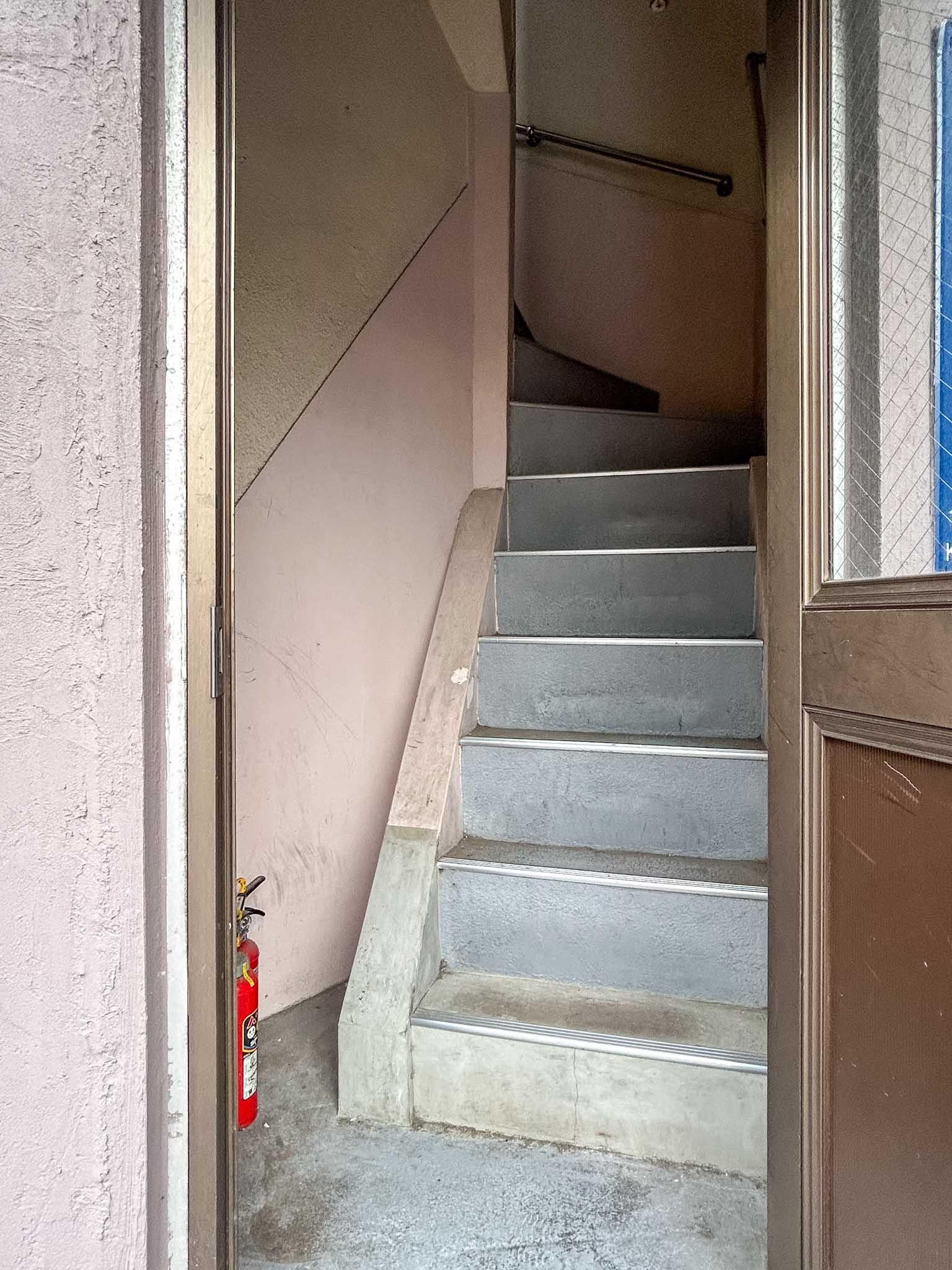 江東区永代の賃貸物件/ブルーのオーニングがかかった扉から上階に上がります