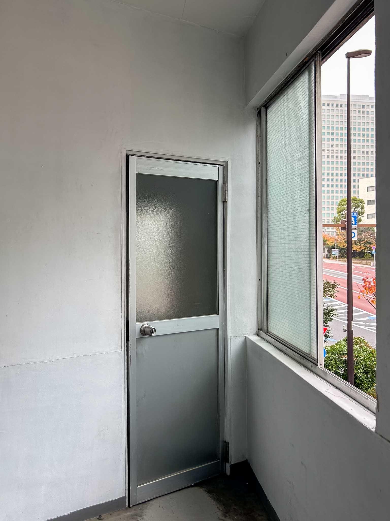 江東区永代の賃貸物件/2階：階段室の扉は、昔ながらのアルミドア