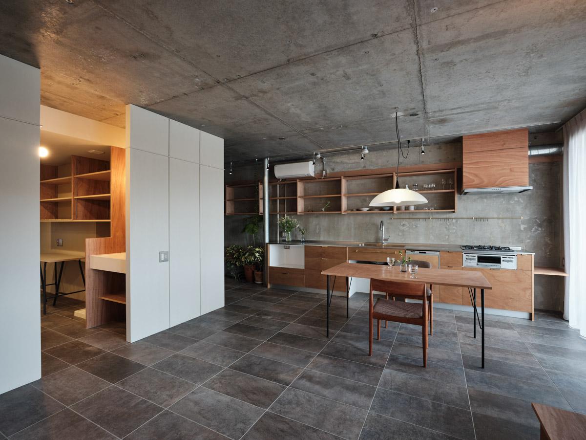 横浜市金沢区能見台の賃貸物件/コンクリートや磁器質タイルの無機質な素材の中に、あたたかみのある木のキッチンや家具が映える（写真：中村晃）