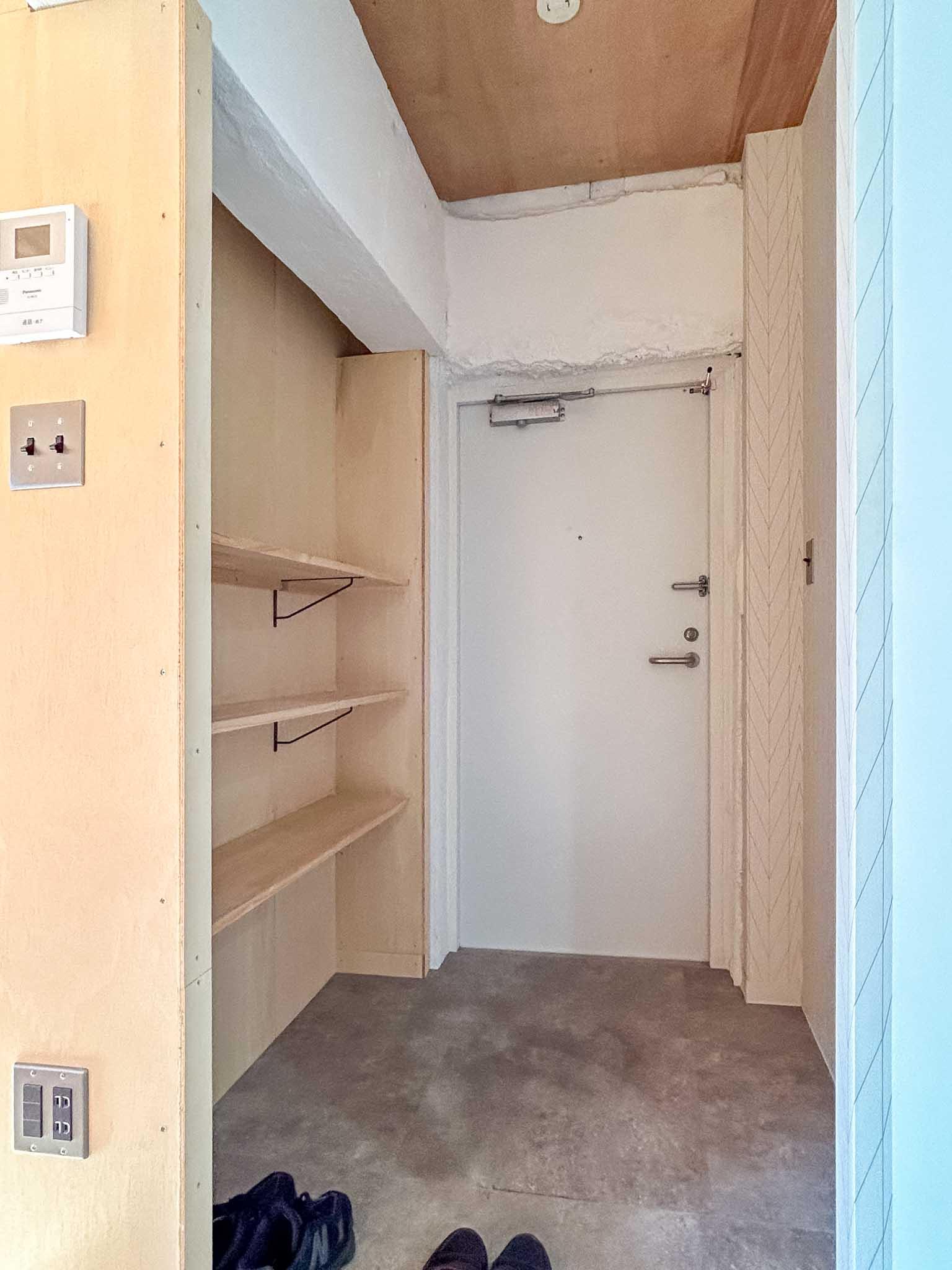 足立区東綾瀬の賃貸物件/412号室：玄関。前入居者のDIYで取り付けられた棚付き