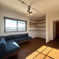 世田谷区砧の賃貸物件/付帯するソファで寛げる南面のエリア、奥に進むと玄関へ