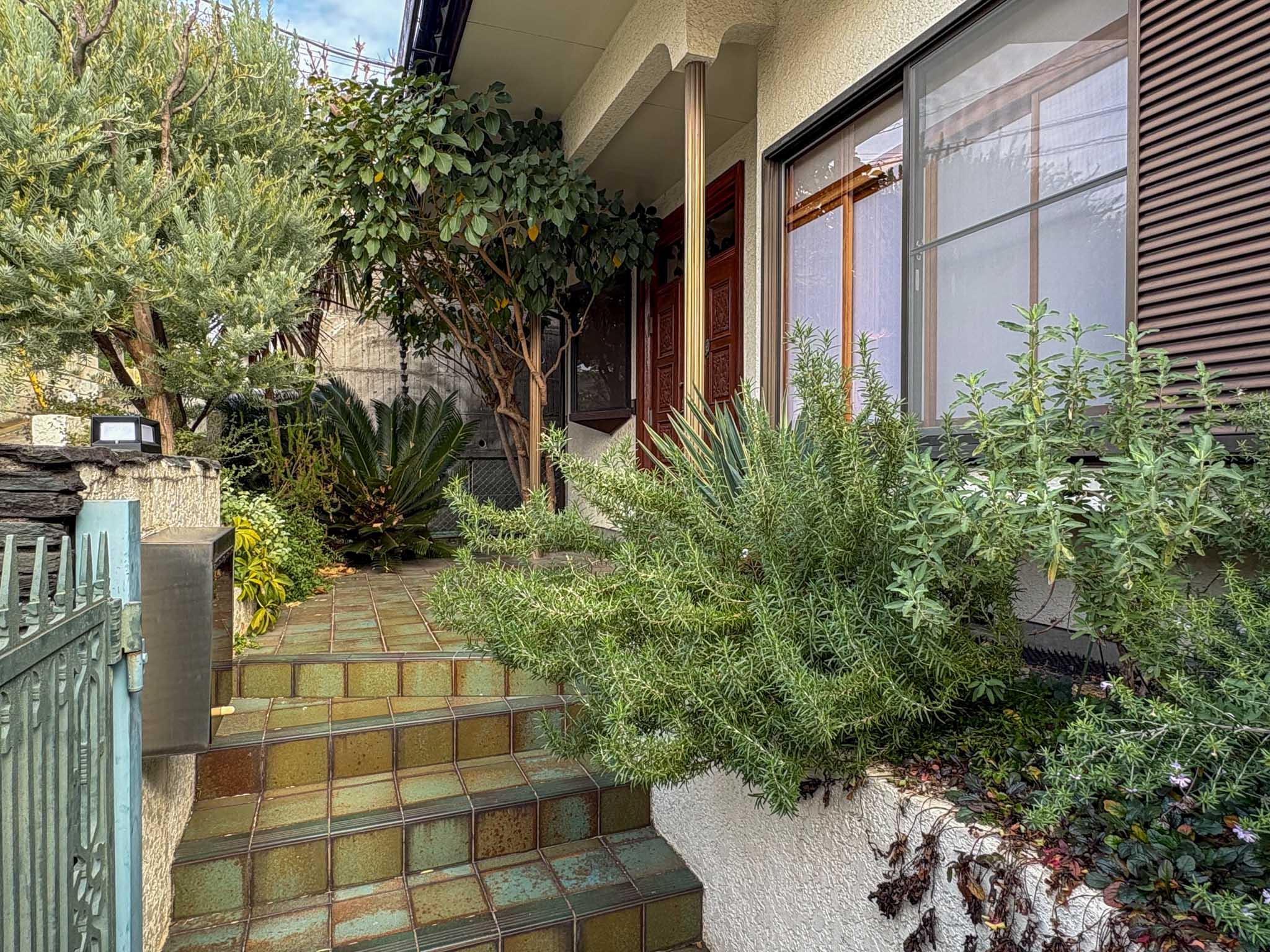 大田区田園調布の賃貸物件/植栽に彩られたアプローチ。緑に包まれて玄関へ続くタイル仕上げの階段