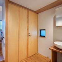 三鷹市井の頭の賃貸物件/1階に水回りがまとまっている形。木の扉の先はトイレと洗濯機置き場。脇に洗面、その右横に浴室があります