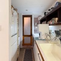 八王子市七国の売買物件/キッチンの作業台の延長線に洗面があり、その奥が浴室