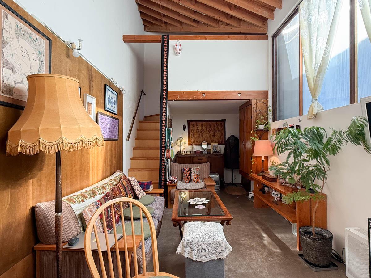 八王子市七国の売買物件/ハイサイドの窓から光が落ちる、吹き抜けのリビング。木の構造をあらわした天井とラフな床が、海外の住宅のよう