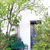 八王子市七国の売買物件/緑に包まれた前庭。大きな石の床、そしてガラスの玄関ドアが住宅とは思えないかっこよさ（写真は夏に撮影のもの）