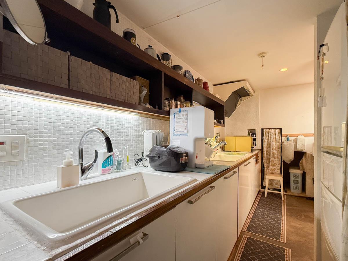 八王子市七国の売買物件/洗面側からキッチンを見る。長く天板が延びる