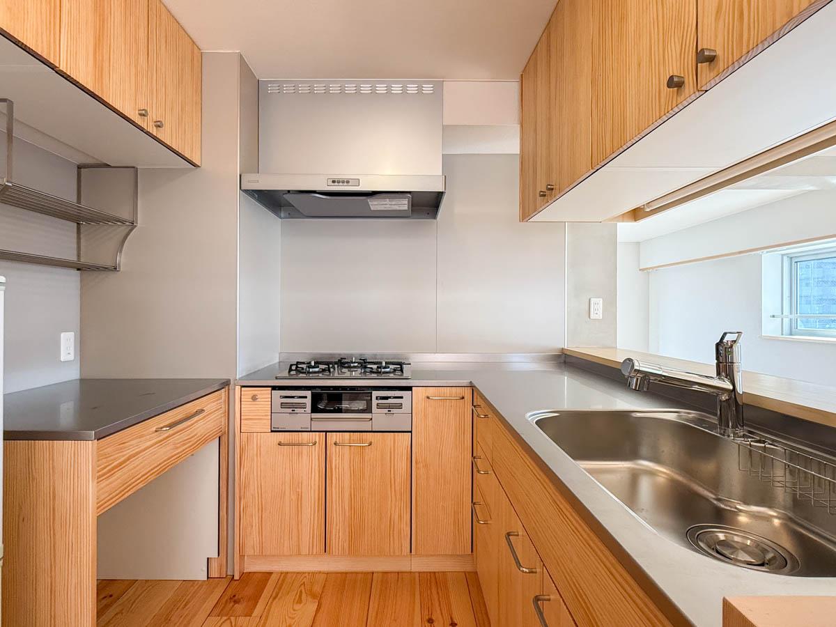 品川区東品川の売買物件/木製の扉がナチュラルで可愛いキッチンは作業性と収納量をしっかり確保。コの字型で調理導線もいい