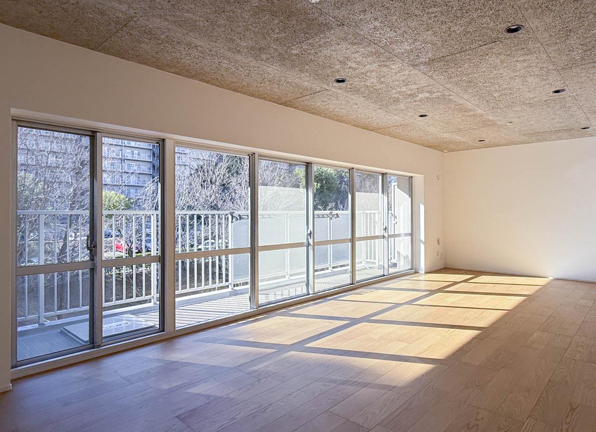 町田市山崎町の売買物件/7連のワイドな窓から光が差し込む、心地よいリビング。暖かくなると敷地の木々が茂り、窓に緑が広がる