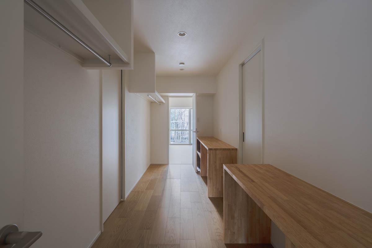 町田市山崎町の売買物件/ウォークスルークローゼット。左手には洋服がかけられ、右手はワークスペースにもできるようなデスクが