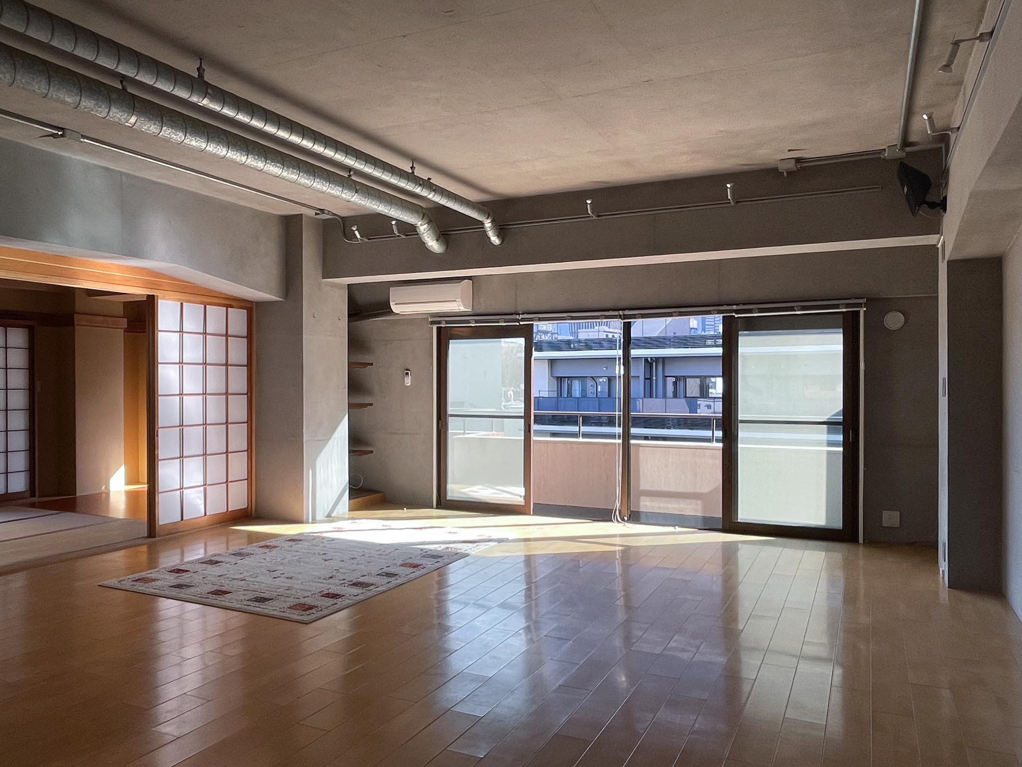 渋谷区代々木の賃貸物件/広さ20畳のゆとりあるリビング。天井には金属製のダクトが走り、空間に無骨な表情を添えています