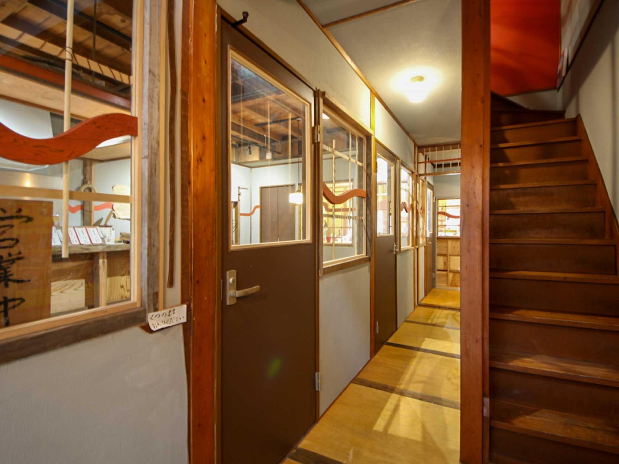 墨田区東向島の賃貸物件/エントランスからみる。左手前に募集区画、廊下の奥にシェアカフェ、階段を上がるとオフィス区画がある