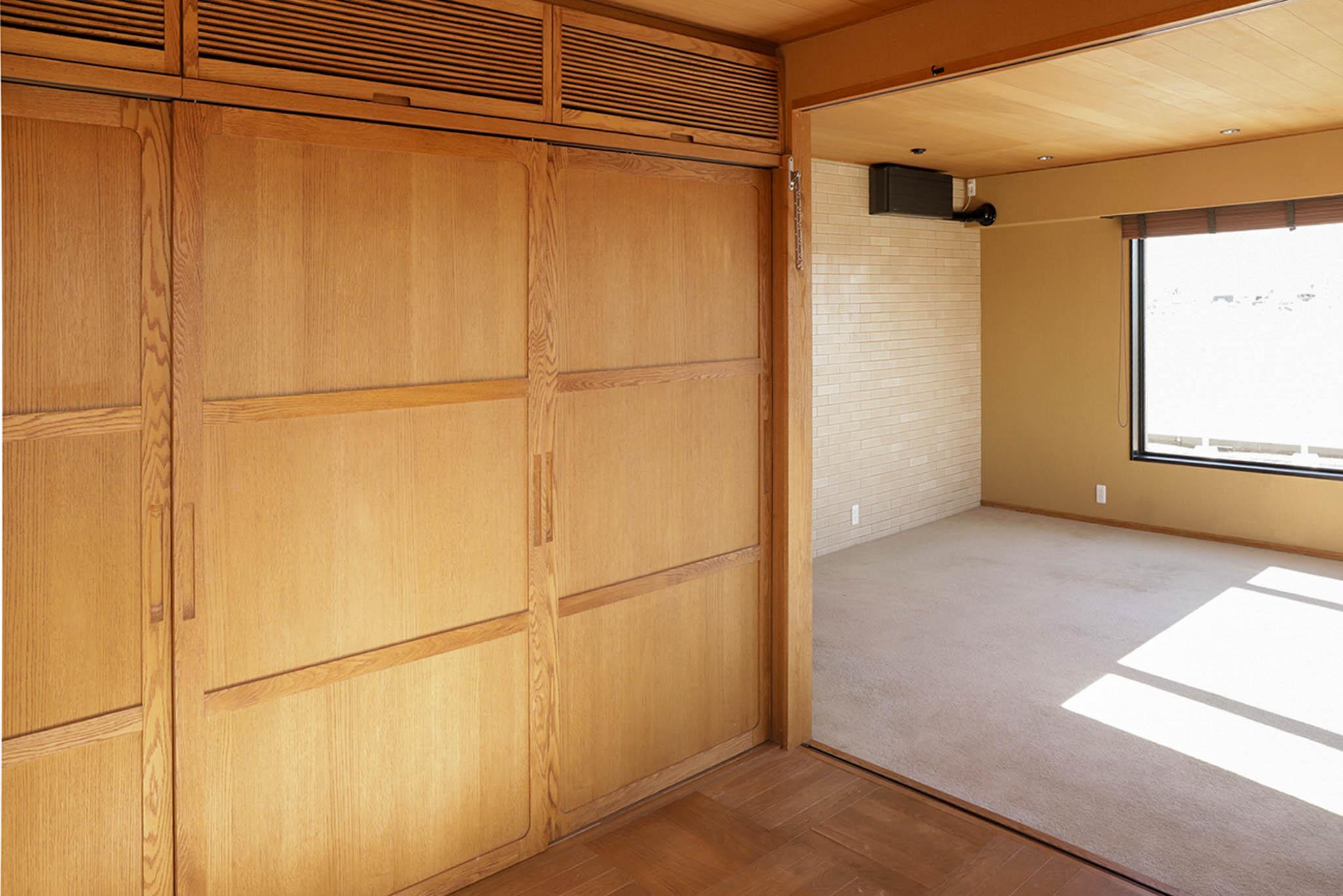 目黒区自由が丘の賃貸物件/大きな木製引き戸の収納が壁一面に。奥にはリビングが続き、空間の広がりを感じられる