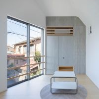 東京都昭島市東町の売買物件/リビング。モルタルのようなグレーの質感をもつフレキシブルボードがアクセント。その裏には人が入れるくらいの広さのある収納スペースがつくられています