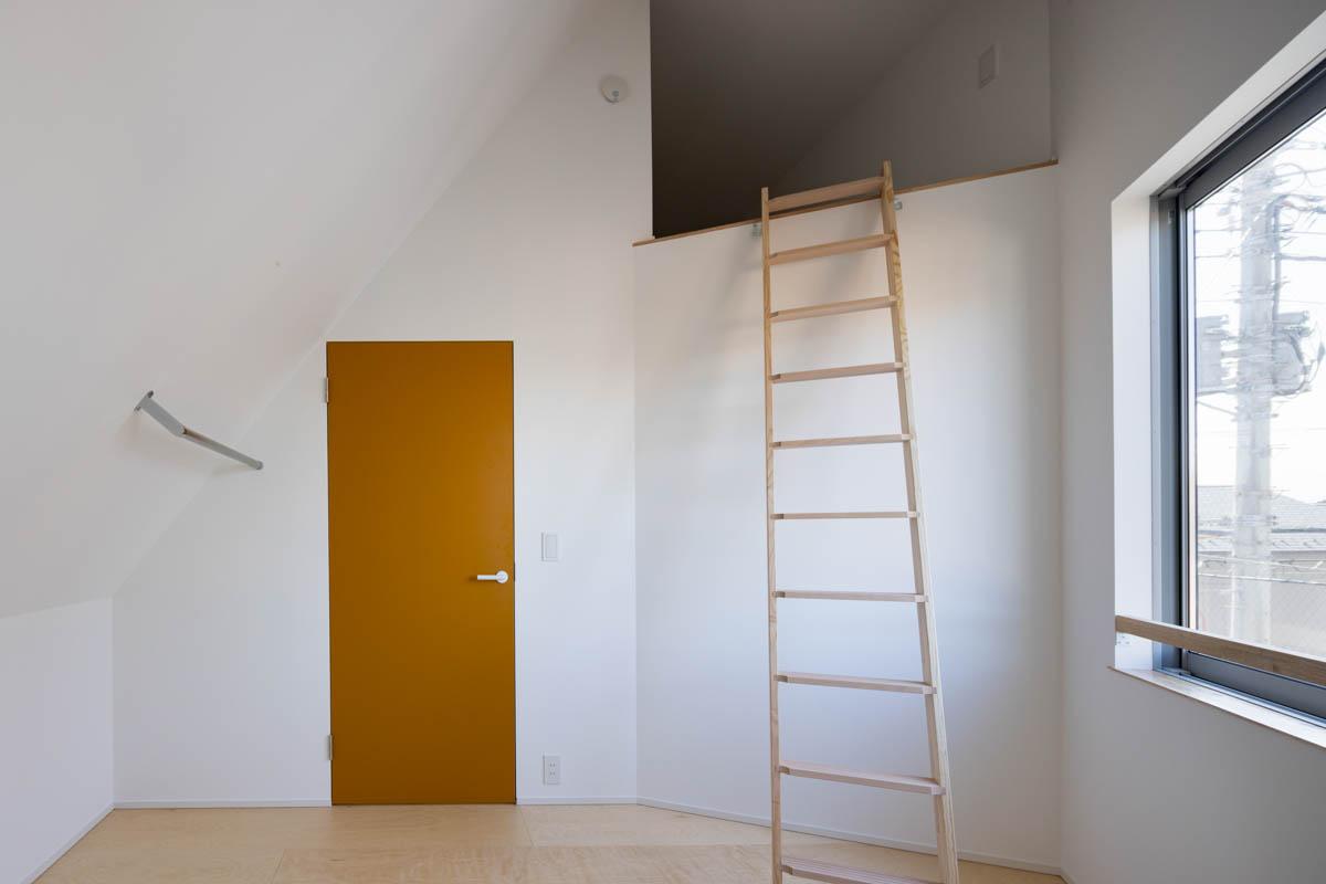 東京都昭島市東町の売買物件/約5.6帖の主寝室。扉の脇のハンガーパイプが洋服掛け。クローゼットはないので工夫が必要