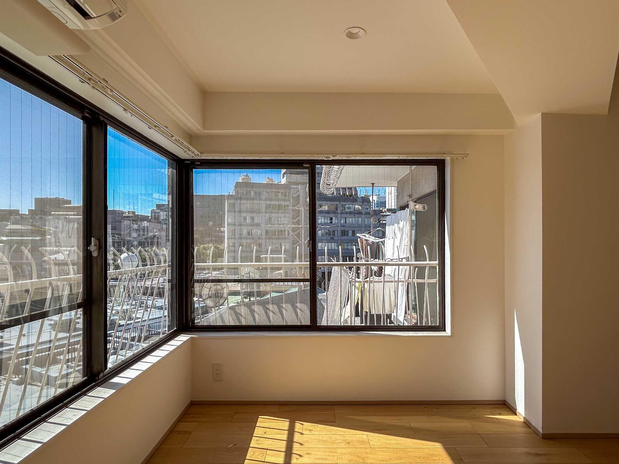 港区赤坂の賃貸物件/9帖のベッドルーム。隣のベランダが目の前にあるので、写真正面のカーテンは必須