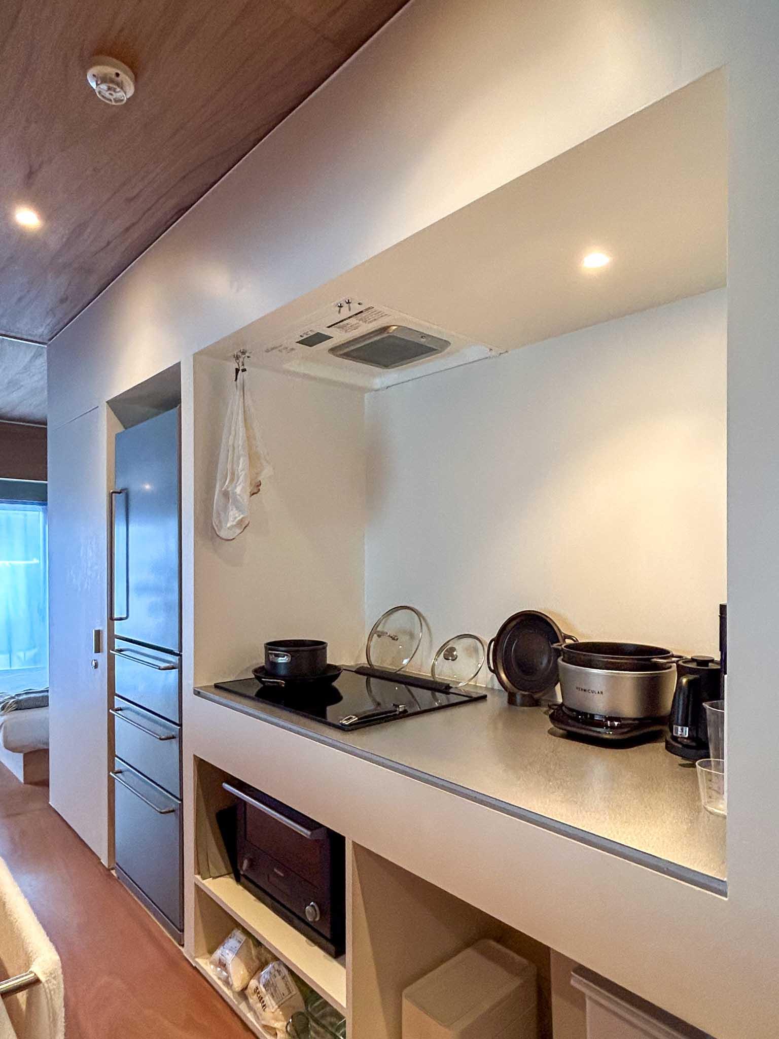 小金井市中町の売買物件/3口IHコンロがある壁側。レンジフードは壁内に納めて、すっきりとした見た目に