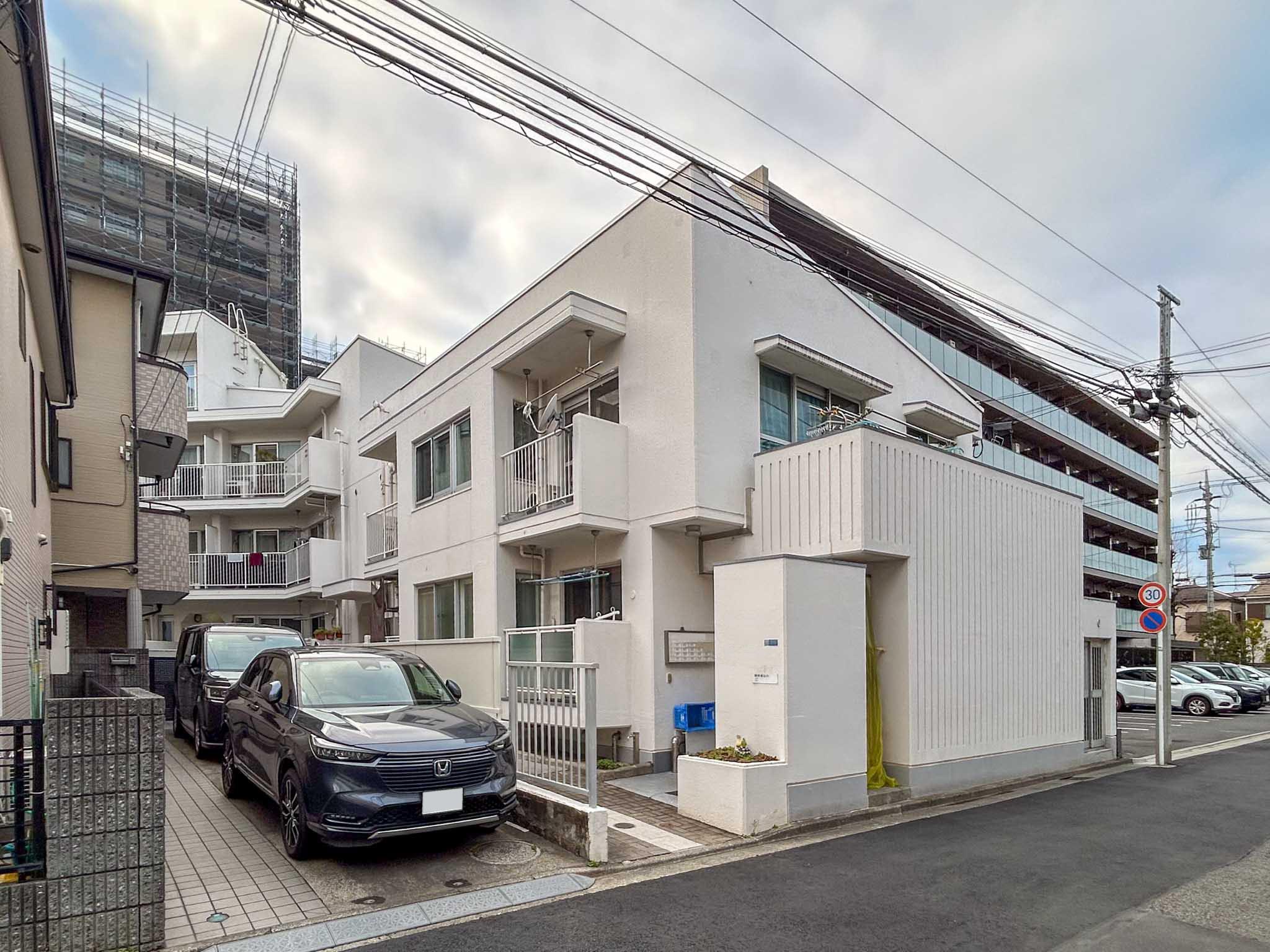 川崎市中原区井田三舞町の売買物件/外観。L字型のマンションで、募集区画は道路から奥まったところにあります